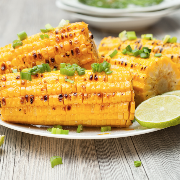 grilled seasoned corn on plate with lime