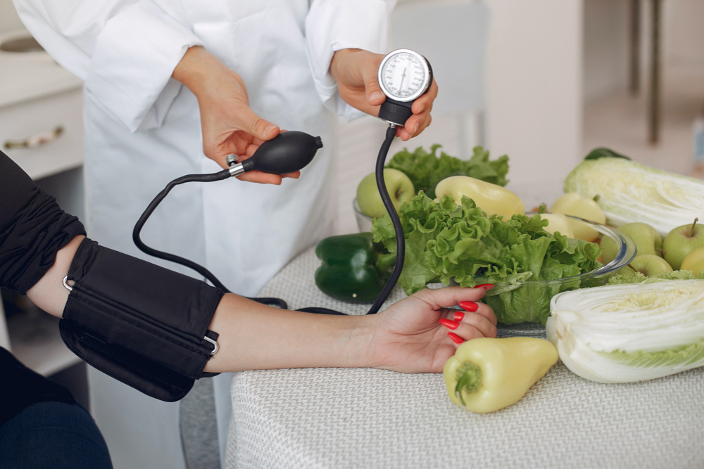 Doctor measures the pressure of the patient in the kitchen