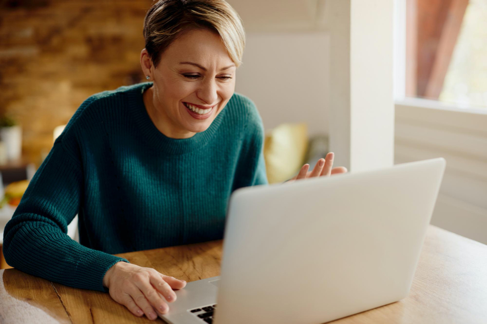 photo happy woman using computer and having fun during video call at hom