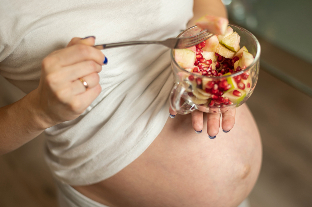 photo pregnant woman hands holding a tasty salad
