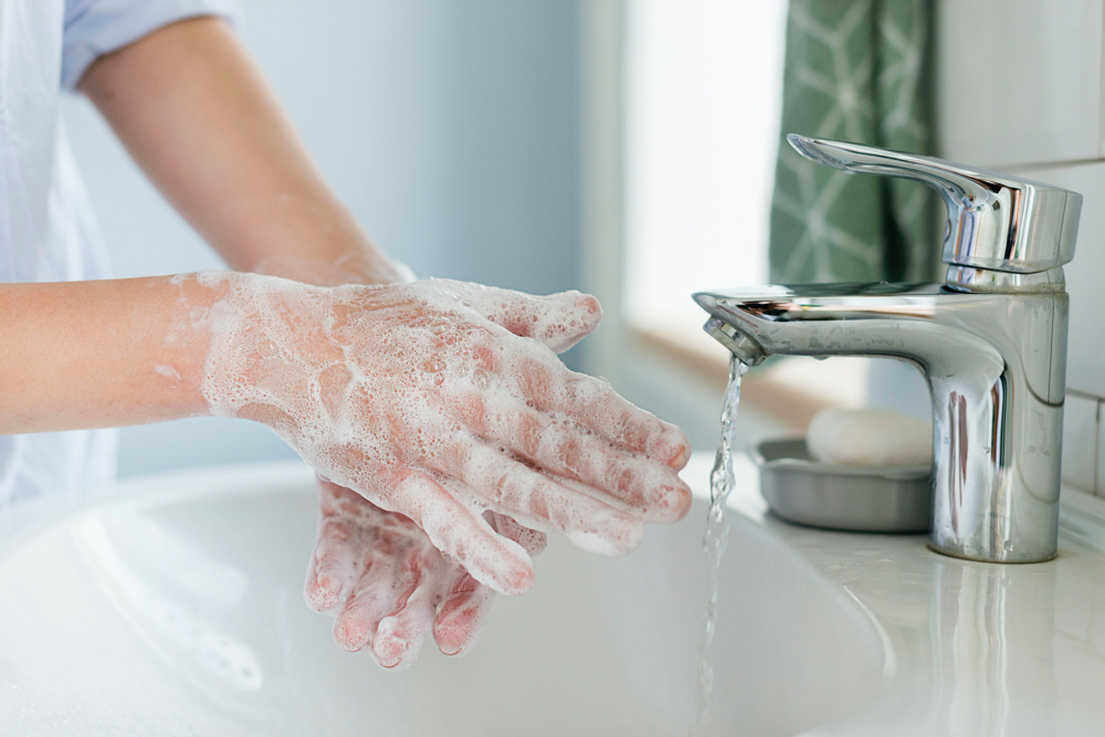 side view of person washing hands in the sink