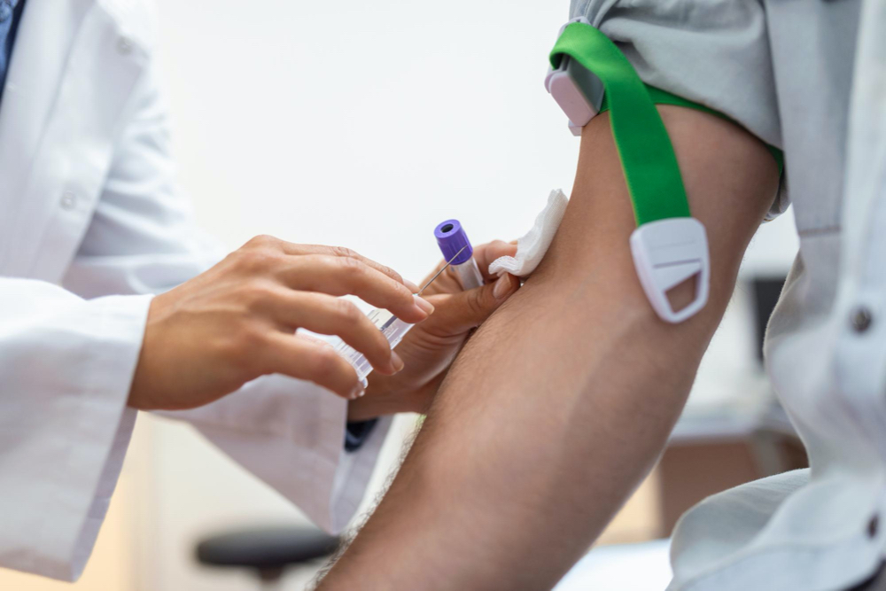 photo preparation for blood test by female doctor medical uniform on the table in white bright room nurse pierces the patient's arm vein with needle blank tube
