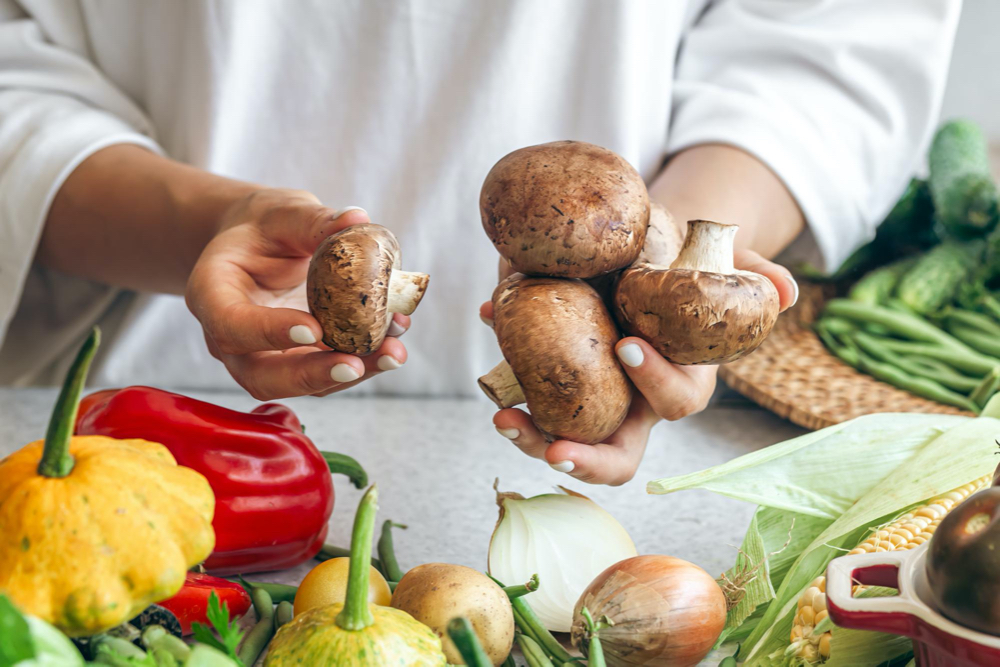 photo raw mushrooms in the hands of a woman in the kitchen