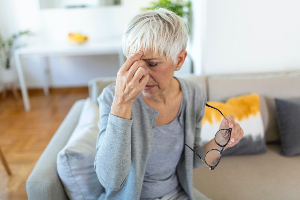 senior woman in glasses rubs her eyes suffering from tired eyes ocular diseases concept
