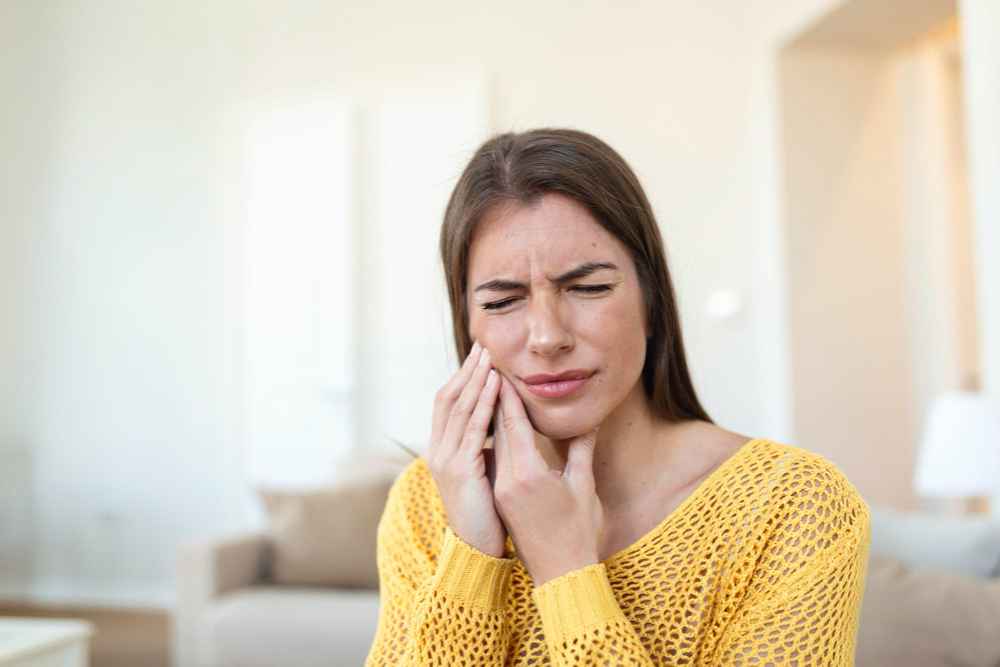 young attractive woman with teeth pain at home