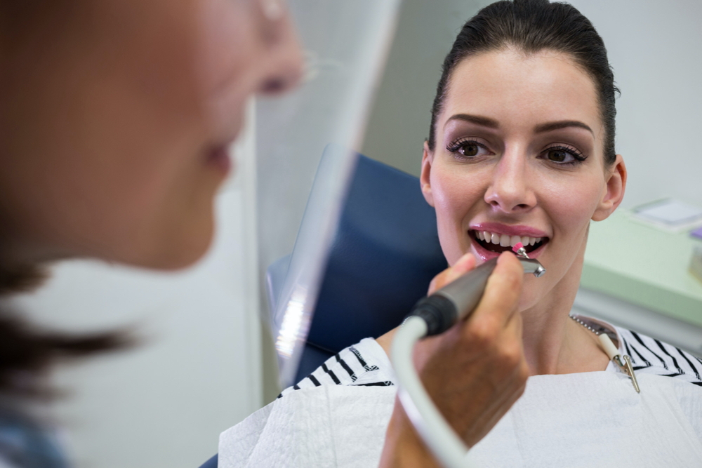 young woman checking her teeth at the dentist