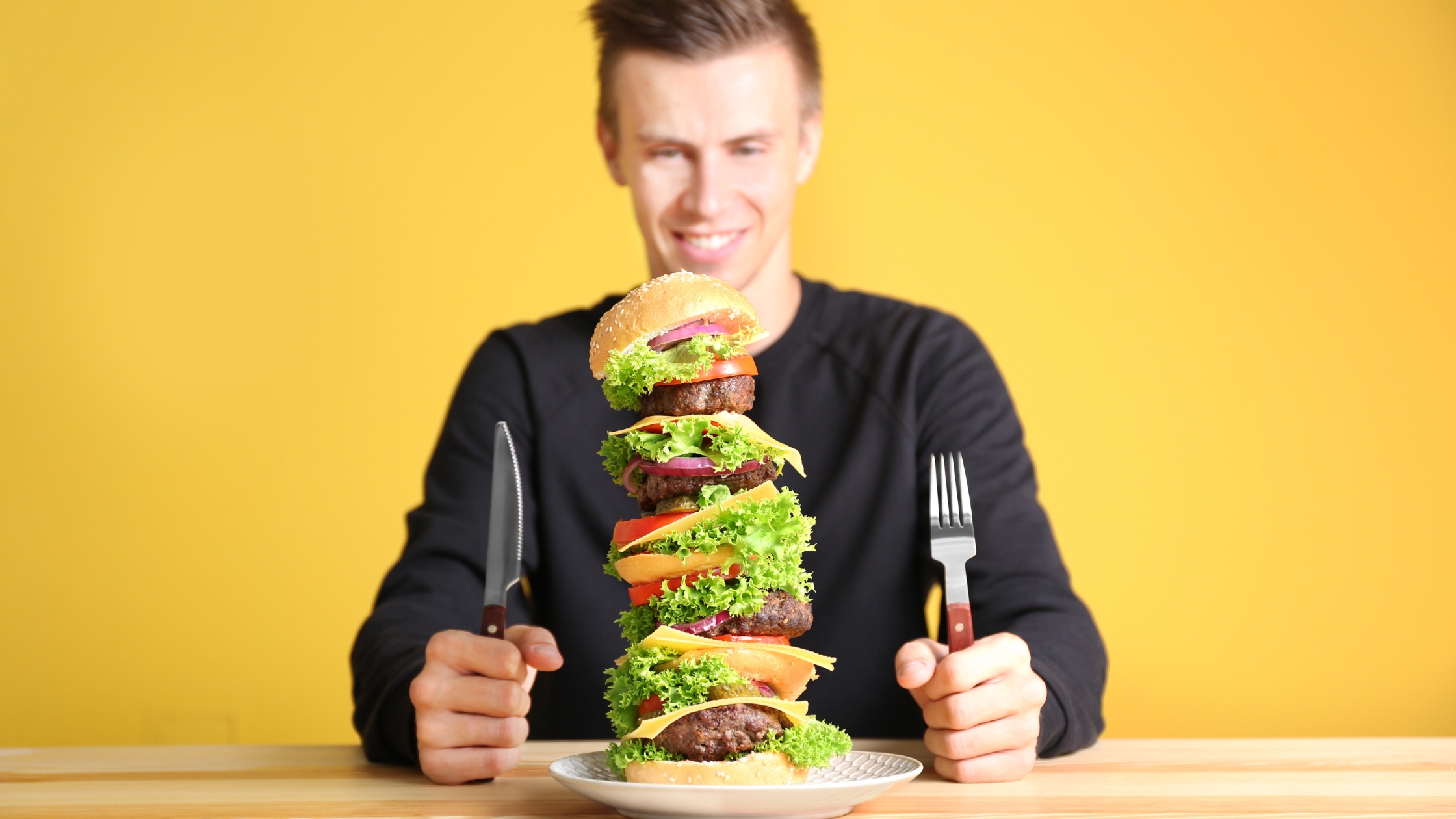 A man eating too much protein in burger meat