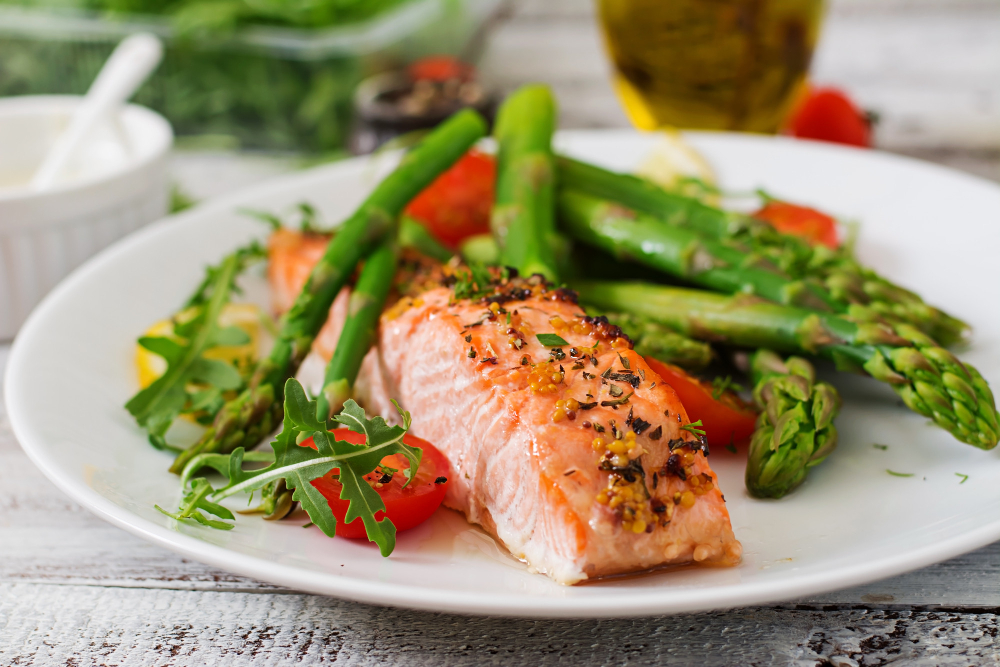 Baked salmon garnished with asparagus and tomatoes with herbs
