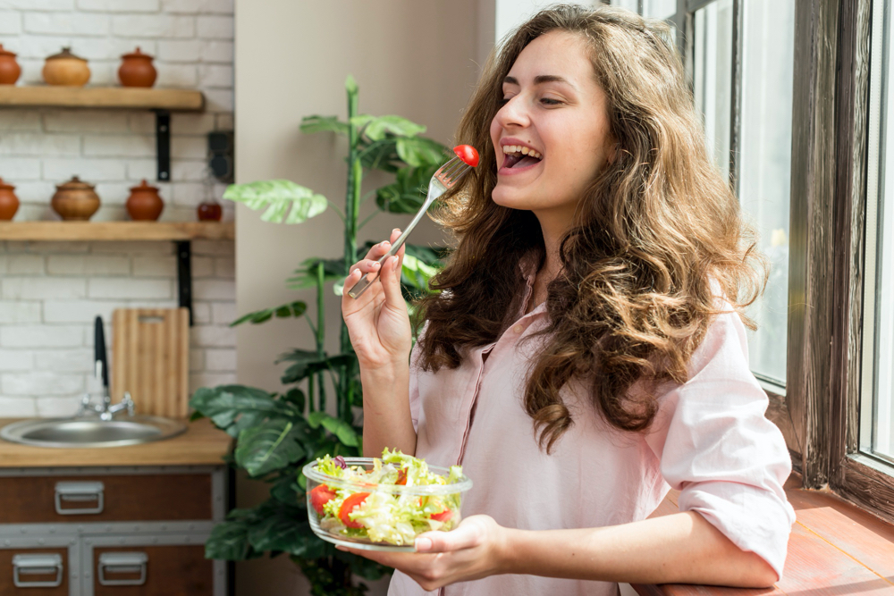 Brunette woman eating a salad trying to alter her diet