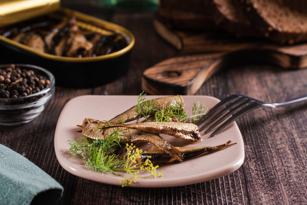 Canned sardines fish in oil and dill on a plate on the table