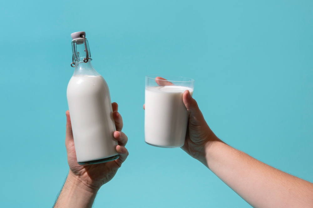 Hand holding milk bottle still life