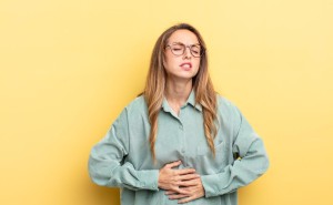 Pretty caucasian woman feeling anxious, ill, sick and unhappy, suffering a painful stomach ache or flu