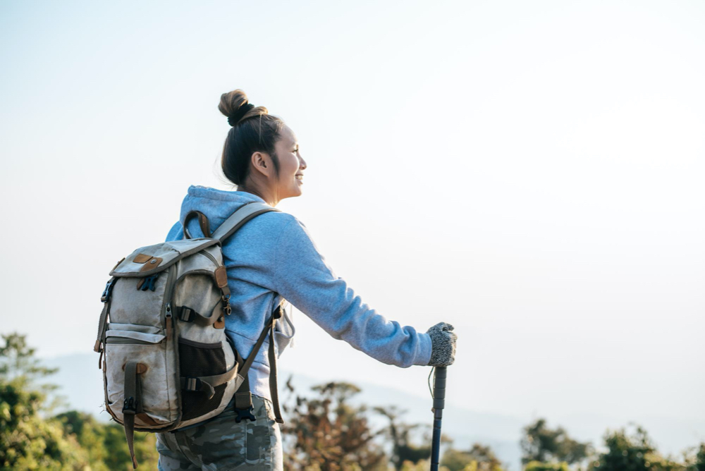 Portrait of Asian young tourist woman is hiking on the top of the mounting and looking at a beautiful landscape with copy space Travel Lifestyle wanderlust adventure concept vacations outdoor