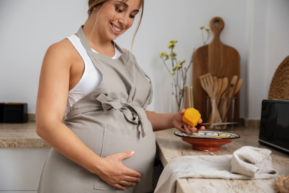 Close up on young pregnant woman cooking
