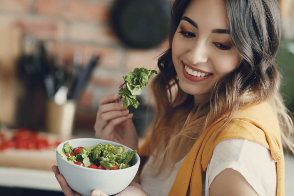 Beautiful young woman eating a healthy salad